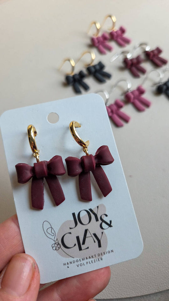 Strikjes oorbellen bordeauxrood detailfoto van Joy & Clay